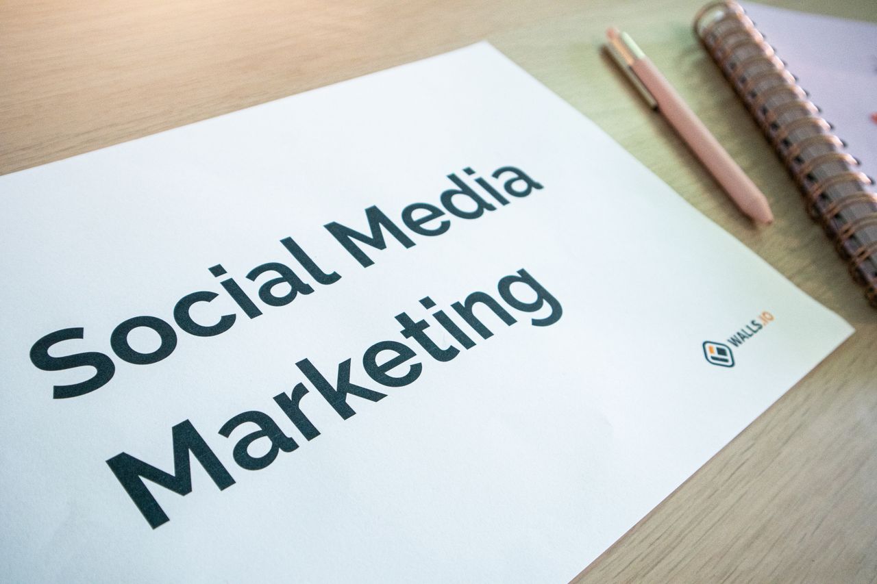 A close-up of a social media marketing document laid out on a desk beside a pen and notebook.
